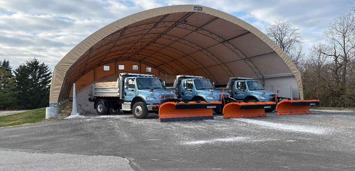 Snow plows in front of salt bin